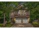 Charming two-story home featuring a two-car garage and a beautifully landscaped front yard with mature trees at 6155 Falls Landing Dr, Cumming, GA 30040