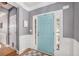 Inviting foyer with beautiful light blue door, wainscoting, and hardwood floors with a stylish area rug at 6155 Falls Landing Dr, Cumming, GA 30040