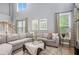 Bright living room features a high ceiling, large sectional sofa, and natural light at 6155 Falls Landing Dr, Cumming, GA 30040