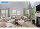 Comfortable living room features a cozy sectional, large windows, fireplace and stylish decor at 6155 Falls Landing Dr, Cumming, GA 30040
