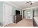 A second view of the main bedroom shows a large dresser and television, as well as access to the ensuite bathroom at 6155 Falls Landing Dr, Cumming, GA 30040