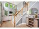 Open staircase leading to a bright living area with large windows, fireplace and hardwood floors at 6155 Falls Landing Dr, Cumming, GA 30040
