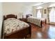 Charming bedroom with two beds, hardwood floors, large windows, and decorative floral accents at 1187 Ward Creek Sw Dr, Marietta, GA 30064