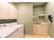 Functional laundry room with washer, dryer, sink, cabinets, and ample storage shelves at 1187 Ward Creek Sw Dr, Marietta, GA 30064