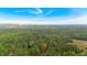 Aerial view of a tree-covered property and surrounding areas under a blue sky at 161 Gann Cemetery Rd, Dallas, GA 30157
