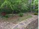 Backyard featuring a stone pathway leading to a wooded area with a firepit at 161 Gann Cemetery Rd, Dallas, GA 30157