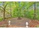 A brick fire pit and patio surrounded by statues and plenty of green trees at 161 Gann Cemetery Rd, Dallas, GA 30157