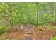 Paver walkway leads to a brick fire pit surrounded by lush green trees at 161 Gann Cemetery Rd, Dallas, GA 30157