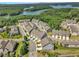 Aerial view of a townhome community shows scenic trees and a body of water at 1610 Habersham Villa Dr, Cumming, GA 30041
