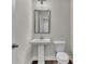 Bathroom with white pedestal sink, modern toilet, and framed mirror at 1610 Habersham Villa Dr, Cumming, GA 30041