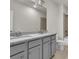 Elegant bathroom vanity with double sinks and a granite countertop, complimented by gray cabinets and modern lighting at 1610 Habersham Villa Dr, Cumming, GA 30041