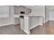 Modern kitchen open to living area with gray cabinets and breakfast bar seating at 1610 Habersham Villa Dr, Cumming, GA 30041