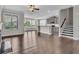Open-concept living area with hardwood floors, staircase, and modern kitchen at 1610 Habersham Villa Dr, Cumming, GA 30041