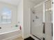 Bright bathroom features white fixtures, natural light, a stand-up shower and soaking tub at 3040 Clear View Ln, Snellville, GA 30078