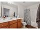 Neutral bathroom has a tub shower combo and a brown wood vanity at 3040 Clear View Ln, Snellville, GA 30078