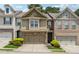 Beautiful townhouse showcasing a stone front, a two-car garage, and manicured landscaping enhancing its curb appeal at 3040 Clear View Ln, Snellville, GA 30078