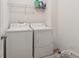 Practical laundry room with washer, dryer, and storage shelf at 3040 Clear View Ln, Snellville, GA 30078