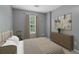 Cozy bedroom featuring a queen-sized bed, dresser with decor, neutral walls and window at 755 Magnolia Gardens Walk, Mcdonough, GA 30253