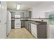 Functional kitchen with gray cabinets, white appliances, and breakfast bar to the living room at 755 Magnolia Gardens Walk, Mcdonough, GA 30253