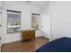 Bright bedroom featuring hardwood floors, two windows with blinds, and a wooden dresser at 93 Terry St # A, Atlanta, GA 30312