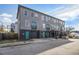 Three-story townhome with gray siding, black brick foundation, and brightly colored doors at 93 Terry St # A, Atlanta, GA 30312
