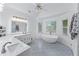 Bright bathroom featuring double vanity, large mirror, and freestanding tub with natural light from large windows at 1775 Potomac Ct, Lawrenceville, GA 30043