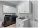 Laundry room featuring front loading washer and dryer, plenty of storage, and utility sink at 1775 Potomac Ct, Lawrenceville, GA 30043
