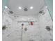 A walk-in shower with gray and white tile, multiple shower heads, and a built-in niche at 1775 Potomac Ct, Lawrenceville, GA 30043