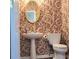Quaint powder room featuring patterned wallpaper, pedestal sink, and modern fixtures at 3703 Liberty Sw Dr, Powder Springs, GA 30127