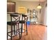 Bright dining area featuring hardwood floors, comfortable counter seating, and a view towards a large sliding glass door at 3703 Liberty Sw Dr, Powder Springs, GA 30127