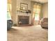 Cozy living room featuring a brick fireplace, neutral carpet, and windows creating a warm space at 3703 Liberty Sw Dr, Powder Springs, GA 30127