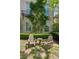 Charming brick home with wooden Adirondack chairs and table on a stone patio surrounded by lush greenery at 6925 Colfax Ave, Cumming, GA 30040