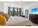 Bedroom features a queen-sized bed, three windows, and hardwood floors; ensuite bath visible at 6925 Colfax Ave, Cumming, GA 30040