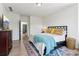 Well-lit bedroom features a queen-size bed, hardwood floors, dresser, and decor at 6925 Colfax Ave, Cumming, GA 30040