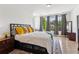 Bright bedroom features a queen-sized bed, hardwood floors, and three large windows at 6925 Colfax Ave, Cumming, GA 30040