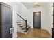 Bright entryway featuring hardwood floors, staircase, and stylish dark-colored doors at 6925 Colfax Ave, Cumming, GA 30040