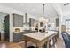 Modern kitchen boasts gray cabinetry, stainless steel appliances, and a large center island with marble countertop at 6925 Colfax Ave, Cumming, GA 30040