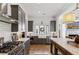 Well-lit kitchen featuring gray cabinets, stainless appliances, farmhouse sink, marble countertops and center island at 6925 Colfax Ave, Cumming, GA 30040