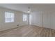 Bedroom with light wood-look floors, two windows, and a double-door closet at 7020 Camp Valley Rd, Riverdale, GA 30296