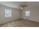 Neutral bedroom featuring two windows, wood-look flooring and a ceiling fan at 7020 Camp Valley Rd, Riverdale, GA 30296
