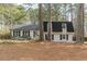Charming two-story home with black shutters, white brick and mature trees at 7020 Camp Valley Rd, Riverdale, GA 30296