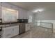 Modern kitchen featuring white cabinets, stainless steel appliances, and a clear view to the living room at 7020 Camp Valley Rd, Riverdale, GA 30296