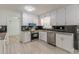 Bright kitchen featuring white cabinets, stainless steel appliances, and modern countertops and backsplash at 7020 Camp Valley Rd, Riverdale, GA 30296