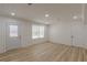 Bright living room featuring wood floors, white walls, recessed lighting, and a door to the outside at 7020 Camp Valley Rd, Riverdale, GA 30296