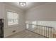 Loft area with natural light, modern railings, and neutral wall paint and flooring at 7020 Camp Valley Rd, Riverdale, GA 30296