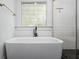 Modern bathroom featuring a freestanding tub, black faucet, and a stained glass window above at 958 Crew Sw St, Atlanta, GA 30315