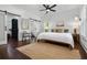 Bright bedroom with a queen bed, shuttered windows, dark hardwood floors, and an ensuite bathroom at 958 Crew Sw St, Atlanta, GA 30315