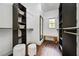 Spacious walk-in closet with dark wood floors, custom shelving, a mirror, and a bench at 958 Crew Sw St, Atlanta, GA 30315