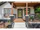 Inviting front porch with stylish railing, modern lighting, a swing, and fresh landscaping at the entry at 958 Crew Sw St, Atlanta, GA 30315