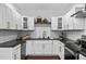 Updated kitchen featuring white cabinets, granite countertops, herringbone backsplash, and stainless appliances at 958 Crew Sw St, Atlanta, GA 30315